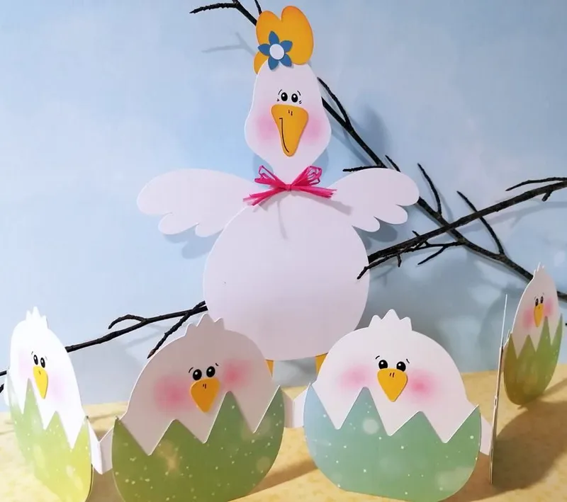 Osterküken in einer Eierschale vor einer Henn aus Bastelpapier