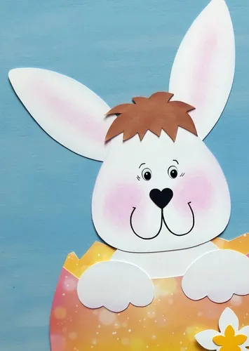 Weißer Hase im buntem Osterei