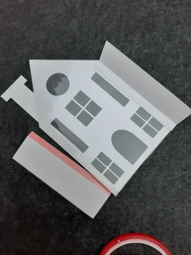 Eine Häuserfront wird mit Sternen-Effektfolie hinterklebt.