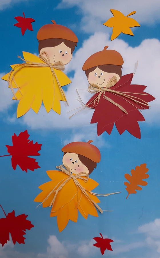 3 fertig gebastelte Blätterkinder mit einem Hintergrund vom Himmel.