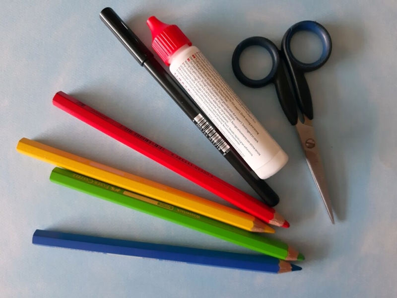 Materialfoto mit Stiften, Kleber und Schere.