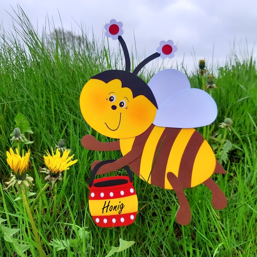 Biene zum Weltbienentag mit Honigtopf auf einer Wiese